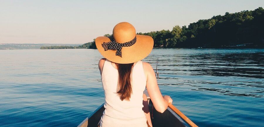woman with a hat sitting in canoe
