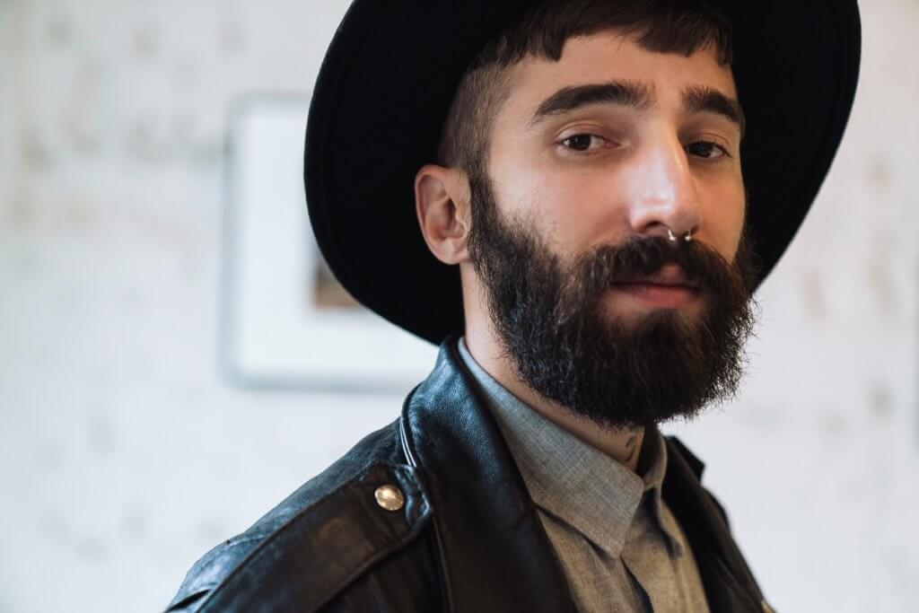 bearded man wearing a hat and nose piercing