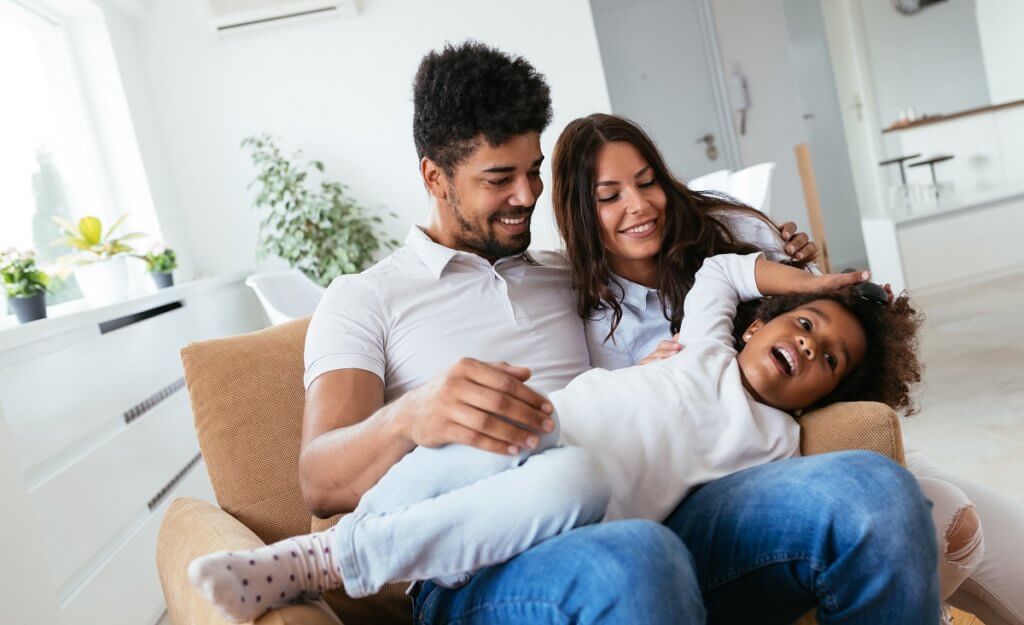 mom, dad and child sitting together on a chair