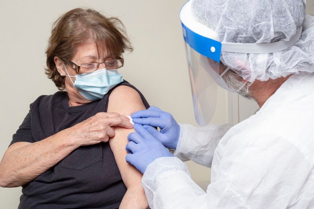 an older woman receiving a vaccine