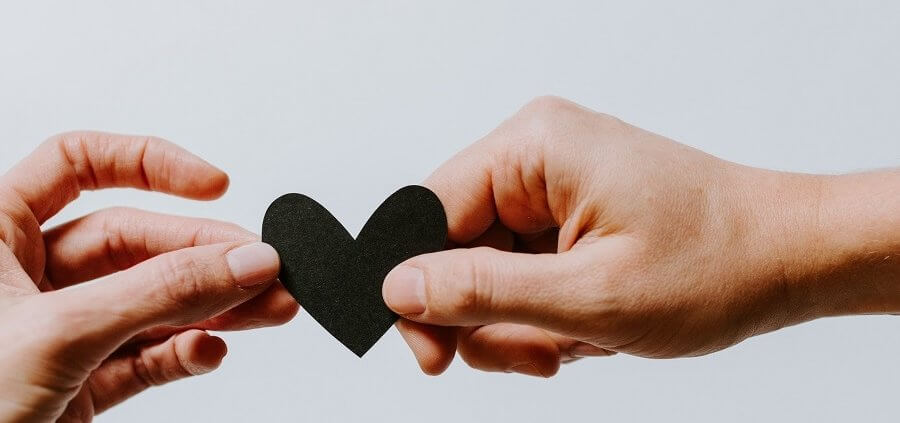 hands holding black paper heart
