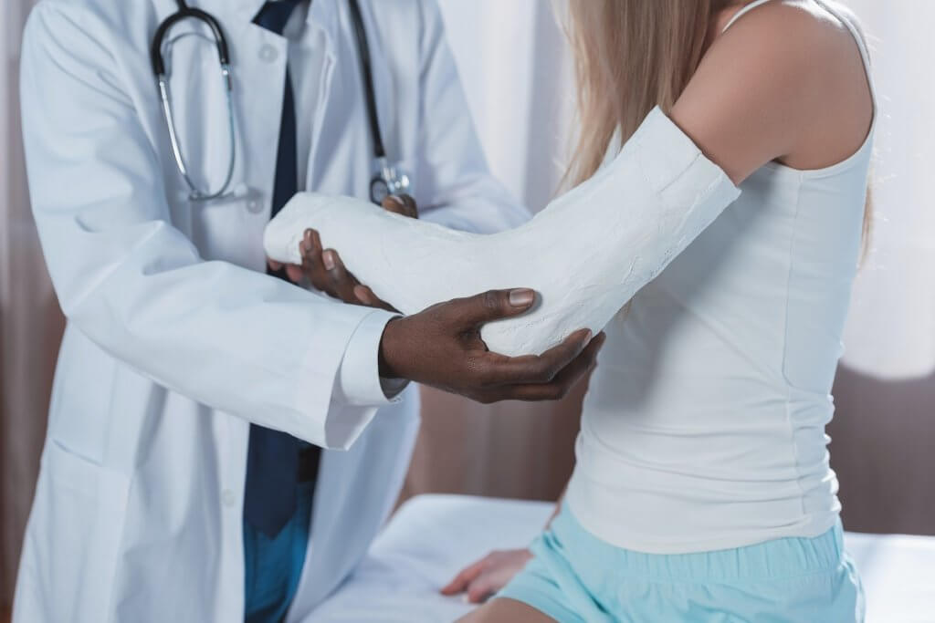 a doctor putting a cast on a woman's arm