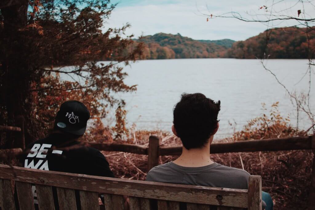 two men sitting on a bench