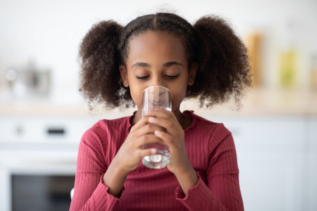 young girl drinking a glass of water