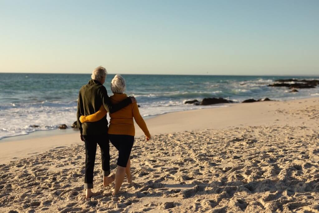 senior couple walking on beach