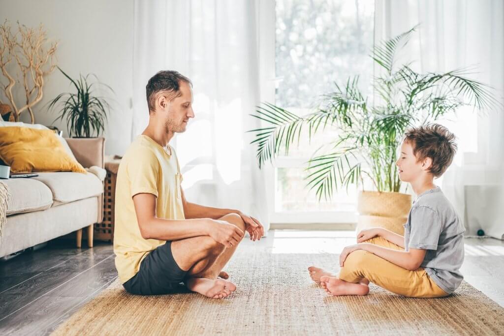 Father and son meditating at home.