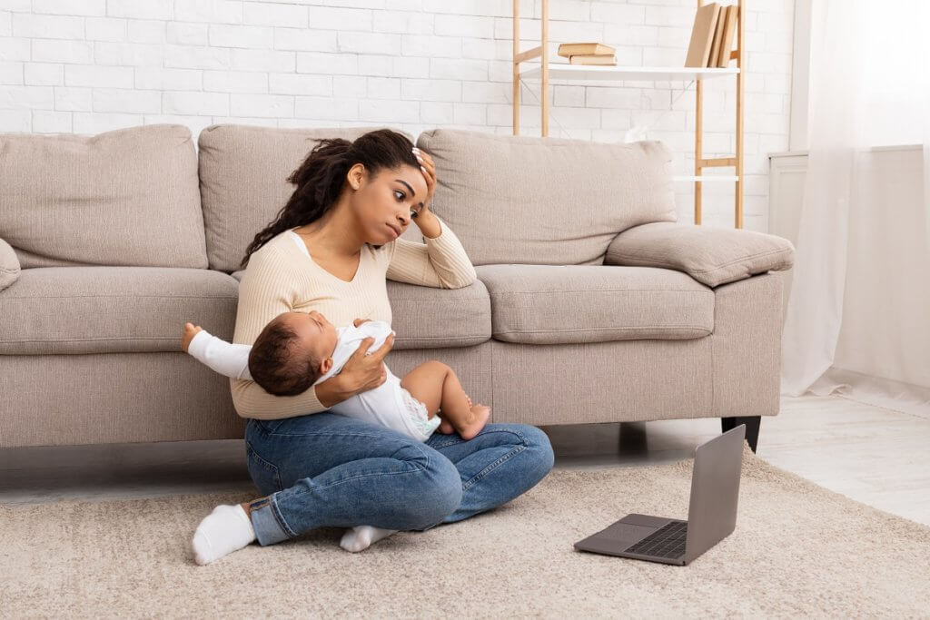 overwhelmed mother holding baby 